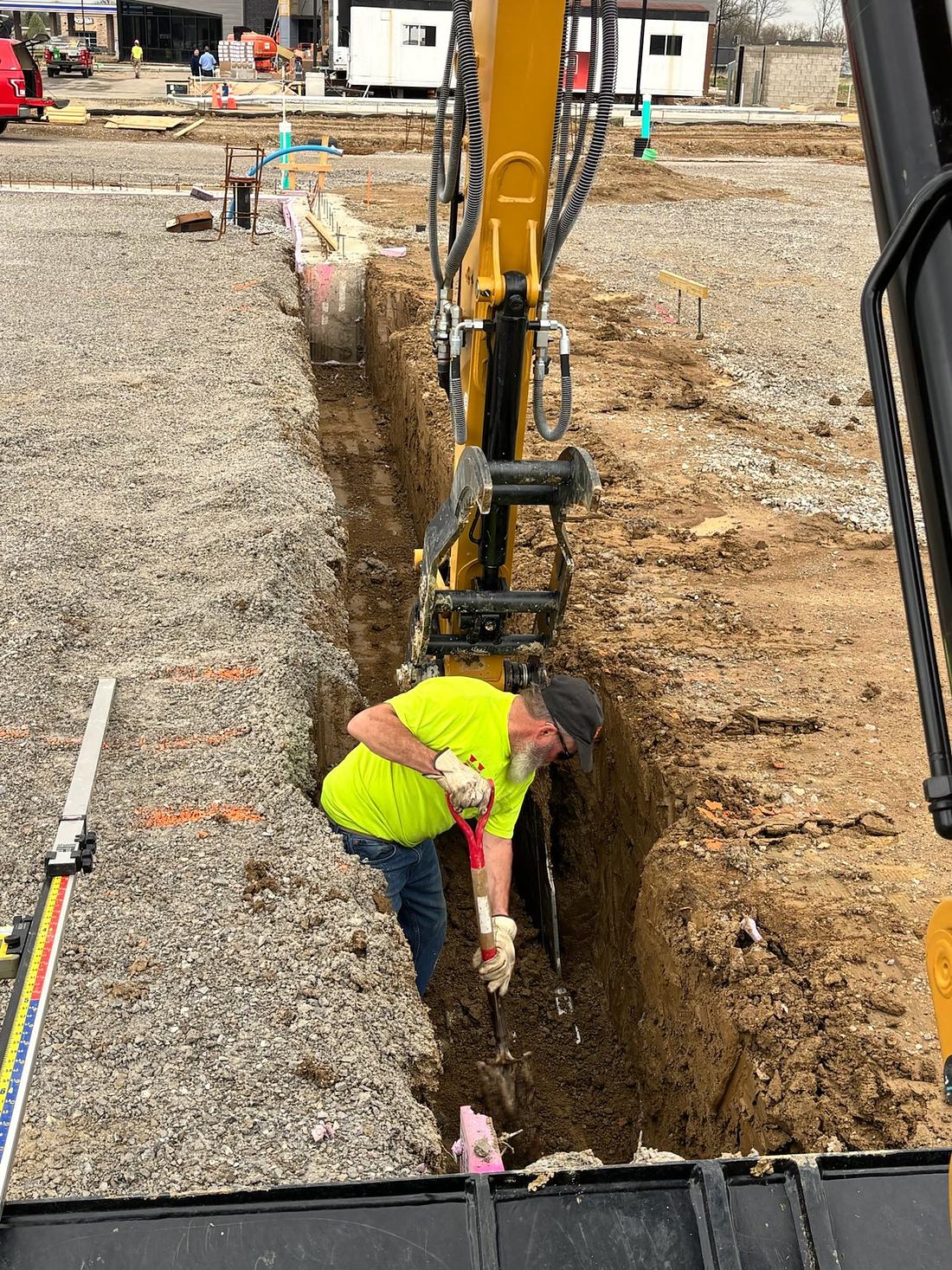 BD Excavation crew checking grade during a commercial utility installation