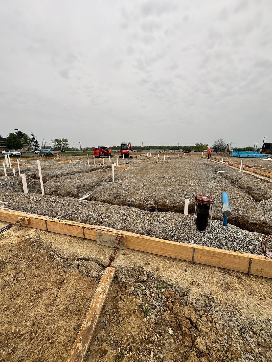 Footing excavation and utility rough-in on a prepared commercial pad