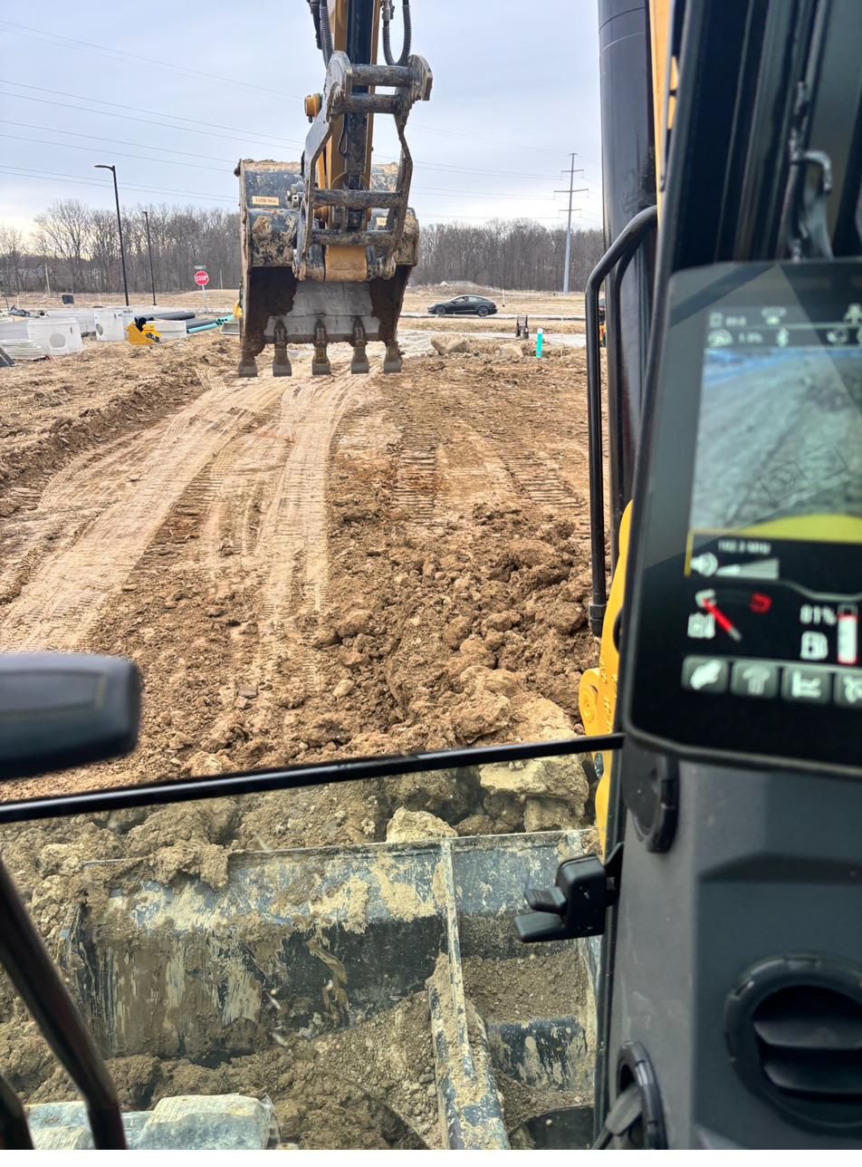 View from the 308 excavator cab over an active earthwork site