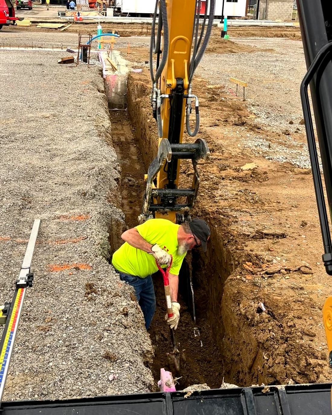 BD Excavation crew checking grade in an open utility trench