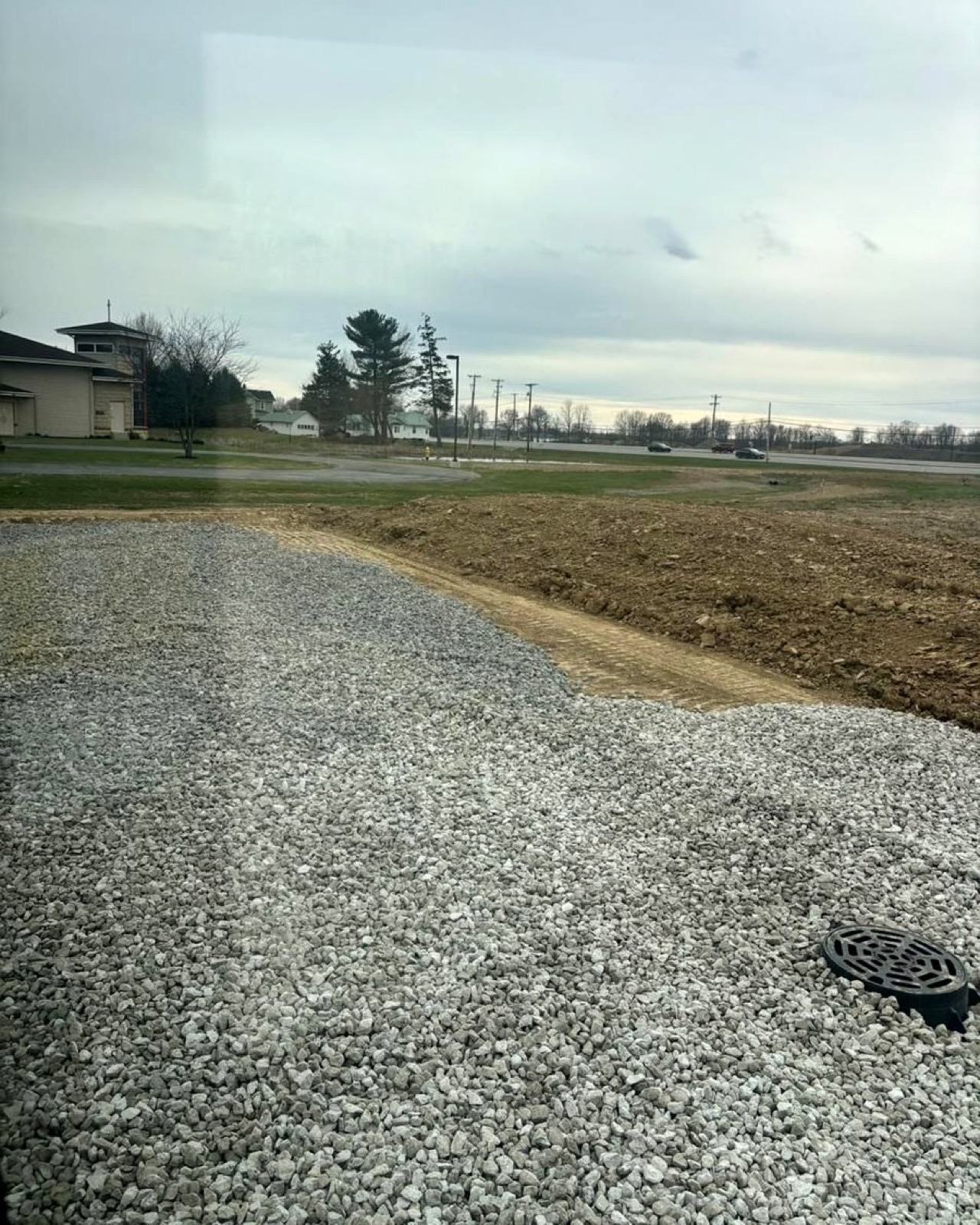 Newly placed crushed stone driveway curving toward a home in Northeast Indiana